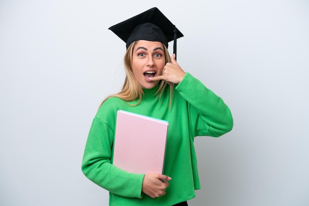 Jonge universitair afgestudeerde vrouw geïsoleerd op een witte achtergrond telefoon gebaar maken Bel me terug teken