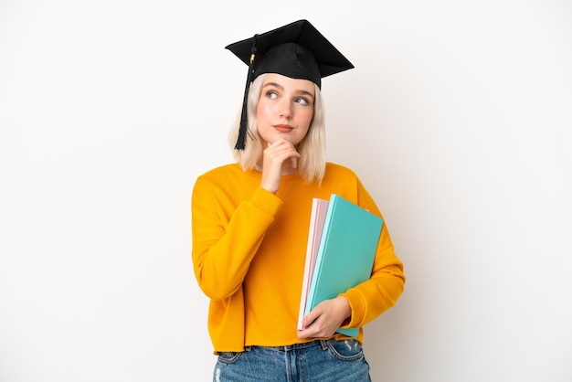 Jonge universitaire blanke vrouw afgestudeerd geïsoleerd op een witte achtergrond en opzoeken