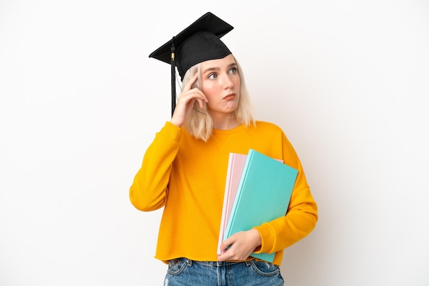 Jonge universitaire blanke vrouw afgestudeerd geïsoleerd op een witte achtergrond met twijfels en denken