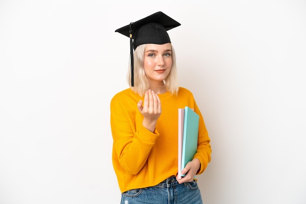 Jonge universitaire blanke vrouw afgestudeerde geïsoleerd op een witte achtergrond die uitnodigt om met de hand te komen. blij dat je gekomen bent