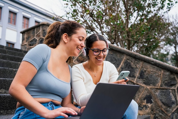 Jonge universiteitsvrienden die telefoon op campus bekijken