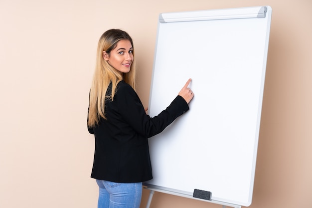 Jonge Uruguayaanse vrouw die een presentatie op wit bord geeft en erin schrijft