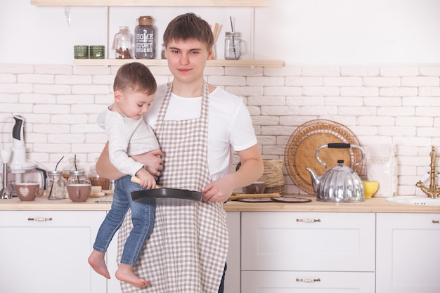 Jonge vader koken met zijn zoontje. Vader en kind op de keuken. Moederdag helpers. Man met kind het maken van een diner of ontbijt voor de moeder.