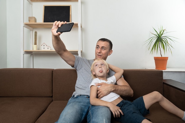 Jonge vader selfie met zijn zoon zitten en gezichten trekken