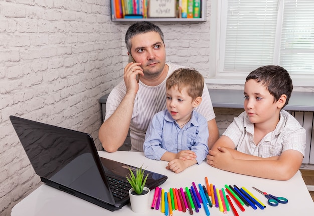 Jonge vader werkt vanuit huis, praten op de mobiele telefoon en babysitten