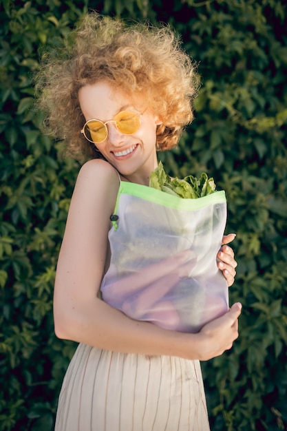 Jonge vegetariër. Een foto van een jonge vrouw met een pakje groente in haar handen