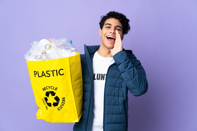 Jonge Venezolaanse man die een zak vol plastic flessen vasthoudt en schreeuwt met wijd open mond