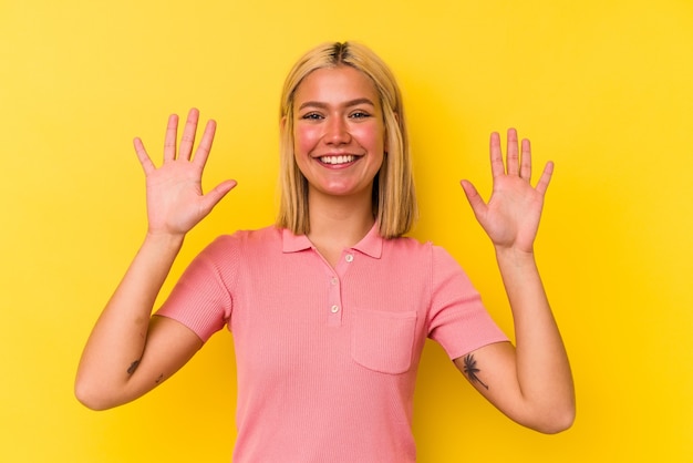 Foto jonge venezolaanse vrouw die op gele muur wordt geïsoleerd die nummer tien met handen toont