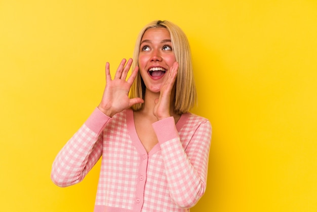 Jonge Venezolaanse vrouw die op gele muur wordt geïsoleerd die opgewonden naar voren schreeuwt.