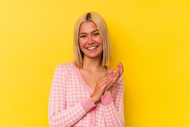 Jonge Venezolaanse vrouw die op gele muur wordt geïsoleerd die zich energiek en comfortabel voelt, zelfverzekerd handen wrijft