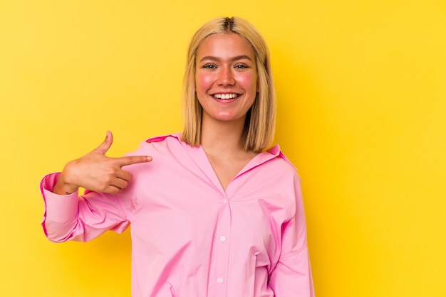 Jonge Venezolaanse vrouw geïsoleerd op gele muur persoon met de hand wijzend naar een shirt kopie ruimte, trots en zelfverzekerd