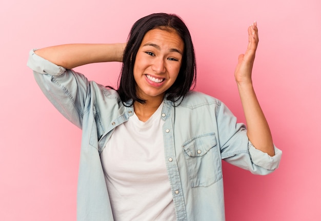 Jonge venezolaanse vrouw geïsoleerd op roze achtergrond schreeuwen van woede.