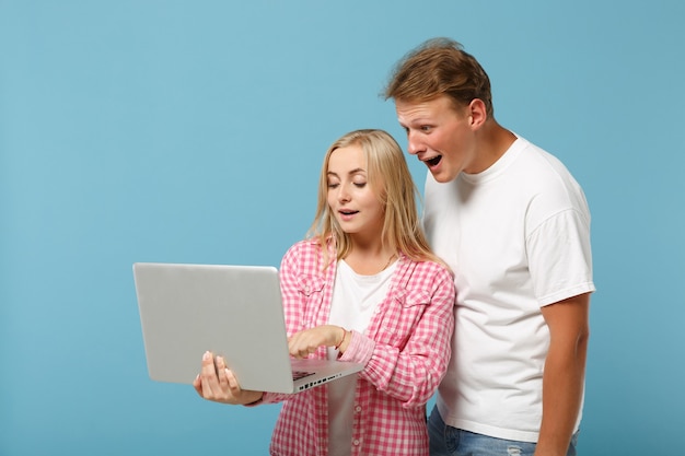 Jonge verbaasde paar vrienden man en vrouw in wit roze lege lege t-shirts poseren