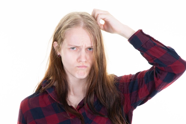 Jonge verbaasde vrouw die aan het hoofd krabt en denkt aan een verkeerd probleem op een witte achtergrond, de gezichtsuitdrukking van het meisje, emotie