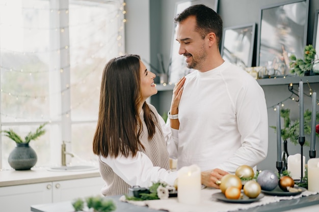 Jonge verliefde paar hebben goede tijd op kerstochtend in de keuken