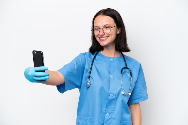 Jonge verpleegster blanke vrouw geïsoleerd op een witte achtergrond die een selfie maakt