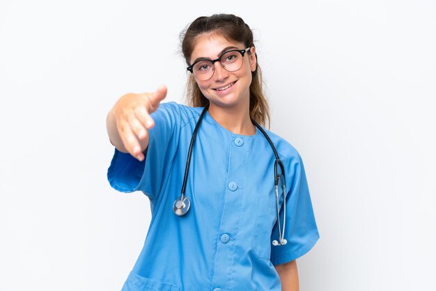 Jonge verpleegster dokter vrouw geïsoleerd op witte achtergrond handen schudden voor het sluiten van een goede deal