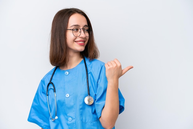 Jonge verpleegster Oekraïense vrouw geïsoleerd op een witte achtergrond wijzend naar de zijkant om een product te presenteren