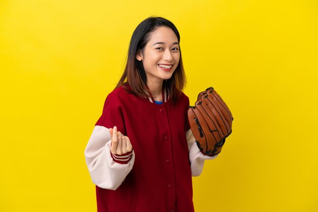 Jonge Vietnamese speler vrouw met honkbal handschoen geïsoleerd op gele achtergrond geld gebaar maken