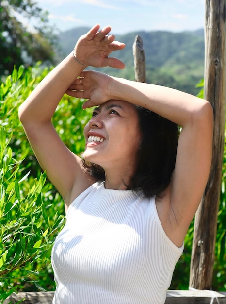 Jonge Vietnamese vrouw die de ogen bedekt tegen de zon tijdens het wandelen in de buitenlucht