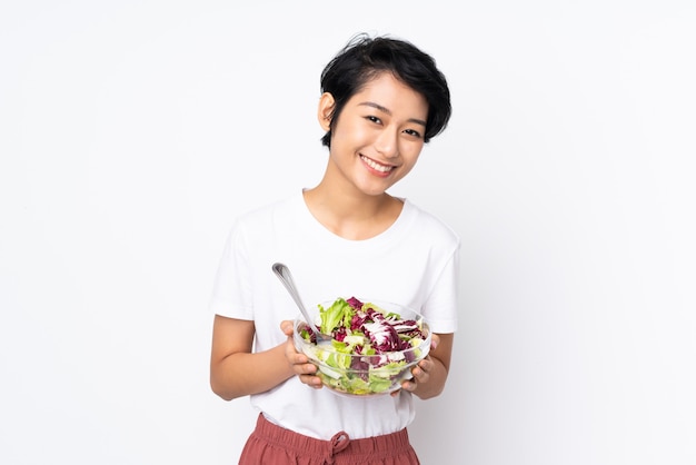 Jonge Vietnamese vrouw die met kort haar een salade houdt