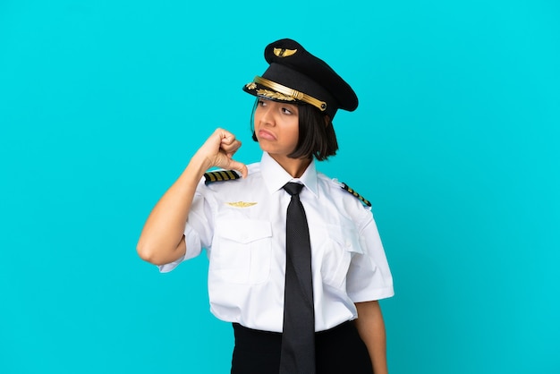 Jonge vliegtuigpiloot over geïsoleerde blauwe achtergrond trots en zelfvoldaan