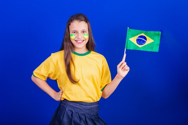 Jonge voetbalfan uit Brazilië die de vlag van Brazilië vasthoudt