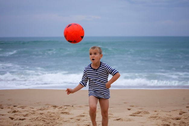 Jonge voetballer speelt op blote voeten op de oceaankust voetbalsport passie actieve levensstijl