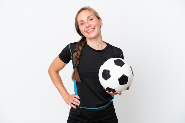 Jonge voetballer vrouw geïsoleerd op een witte achtergrond poseren met armen op heup en lachend