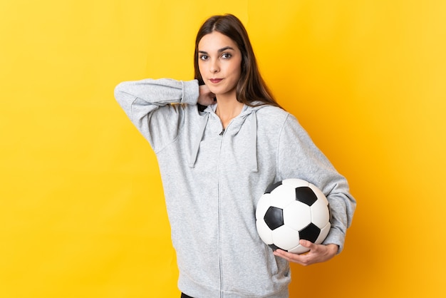 Jonge voetbalster vrouw geïsoleerd op gele muur lachen