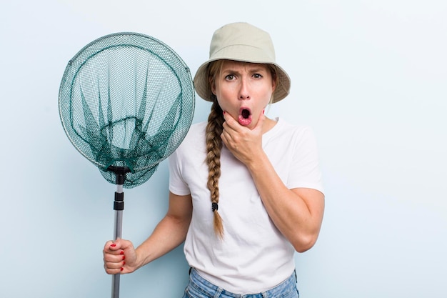 Jonge volwassen blonde vissersvrouw met een netto vakantie- en hobbyconcept