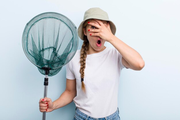 Jonge volwassen blonde vissersvrouw met een netto vakantie- en hobbyconcept