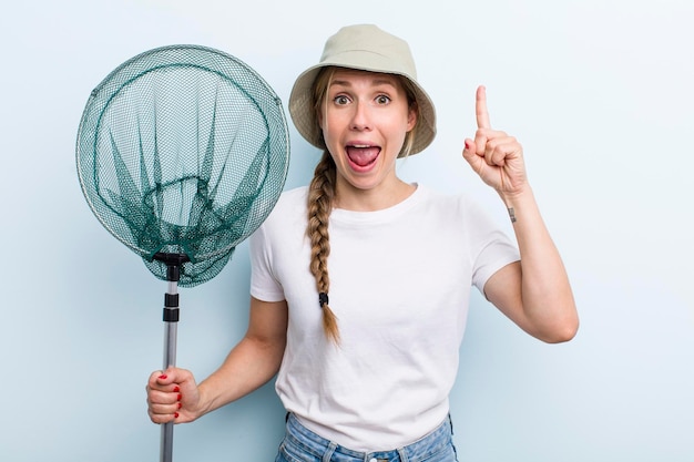 Jonge volwassen blonde vissersvrouw met een netto vakantie- en hobbyconcept