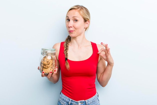 Jonge volwassen blonde vrouw met zelfgemaakte koekjes