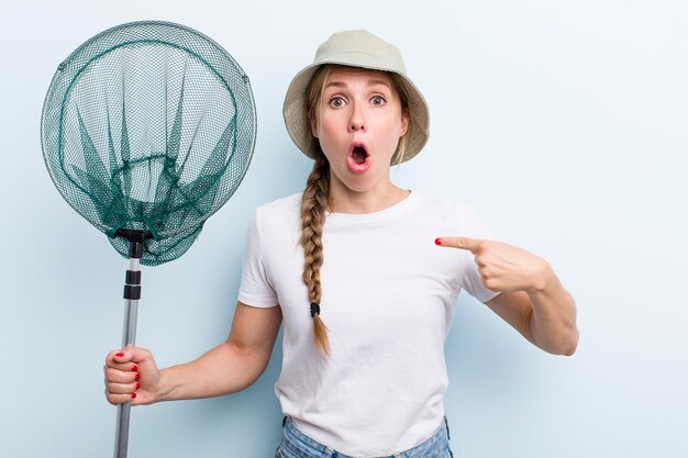 Jonge volwassen blonde vrouw visser met een net en zomer concept