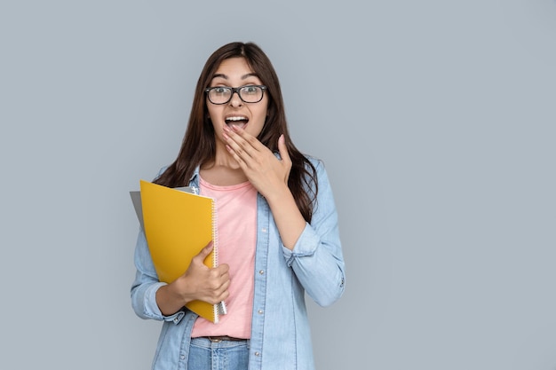 Jonge volwassen Indiase student die zijn mond met zijn hand bedekt.