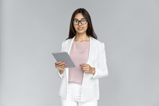 Jonge volwassen Indiase vrouw met tablet in handen camera kijken