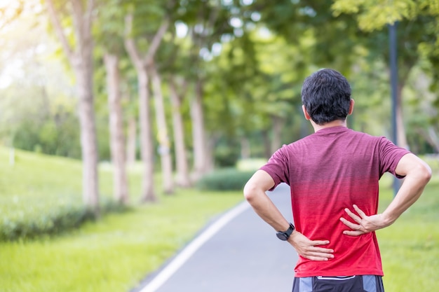 Jonge volwassen man met zijn spierpijn tijdens het hardlopen