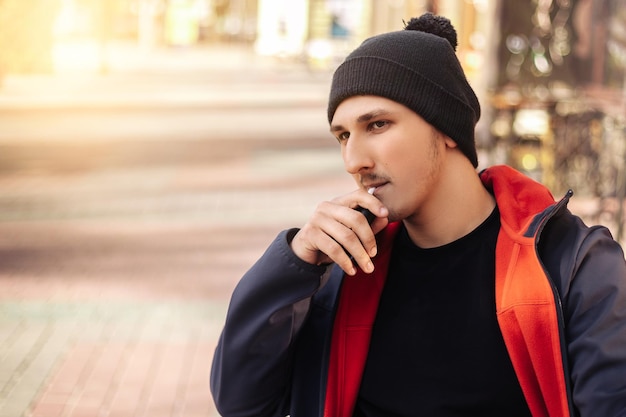 Jonge volwassen man rooktabak apparaat elektronische sigaret heater