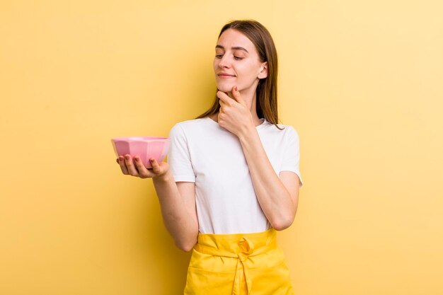 Jonge volwassen mooie chef-kokvrouw met een lege kom