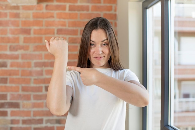 jonge volwassen mooie vrouw die ongeduldig en boos kijkt, naar de wacht wijst, om stiptheid vraagt, wil op tijd zijn