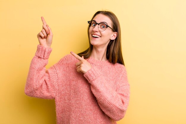 Jonge volwassen mooie vrouw geïsoleerd tegen gele muur