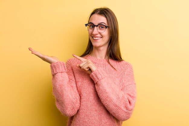 Jonge volwassen mooie vrouw geïsoleerd tegen gele muur