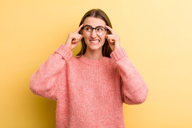 Jonge volwassen mooie vrouw geïsoleerd tegen gele muur