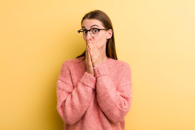 Jonge volwassen mooie vrouw geïsoleerd tegen gele muur