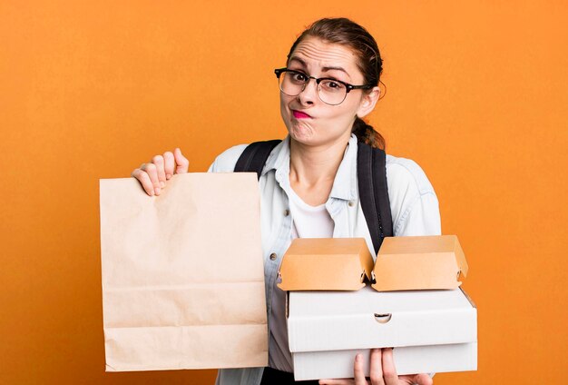 Jonge volwassen mooie vrouw met afhaalmaaltijden fastfooddozen