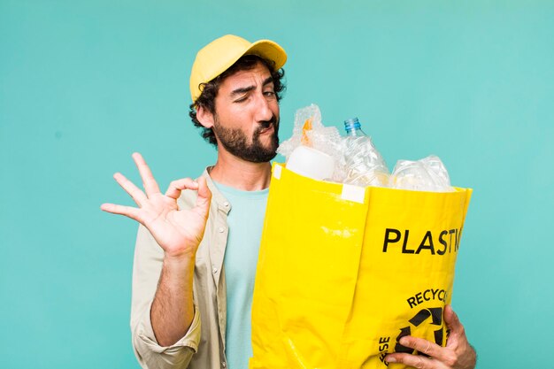 Jonge volwassen Spaanse gekke man die een ecologieconcept recyclet