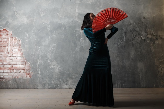 Jonge volwassen Spaanse vrouw flamenco dansen op grijze vintage achtergrond