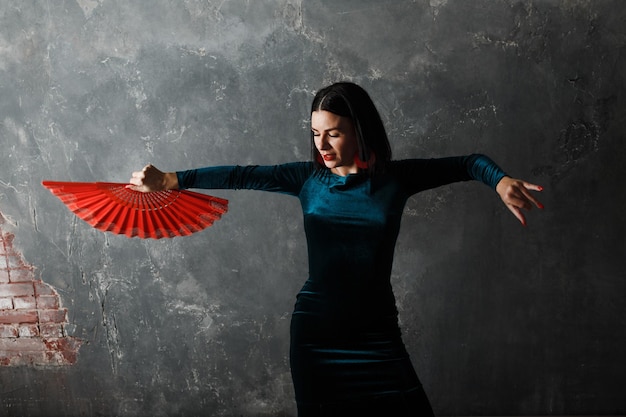 Jonge volwassen Spaanse vrouw flamenco dansen op grijze vintage achtergrond