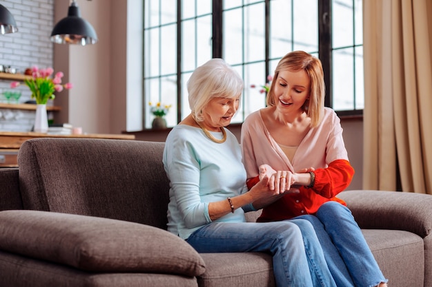 jonge volwassen vrijwilliger in gesprek met een ouder wordende vrouw op de bank